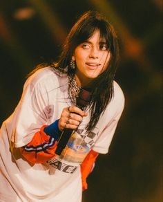 a woman with long hair holding a microphone