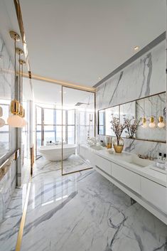 a large bathroom with marble floors and gold accents on the walls, along with two sinks