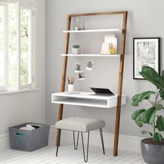 a white desk with a ladder shelf next to it and a potted plant in the corner