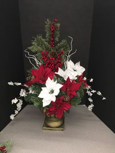 a vase filled with red and white flowers