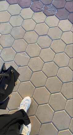 a person standing on the ground with their feet up in front of a black bag