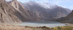 the mountains are covered with snow and water in this photo, there is a river running between them