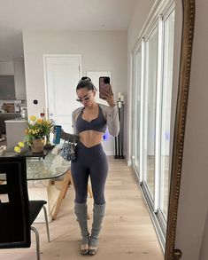 a woman is taking a selfie in the mirror while wearing leggings and high heels