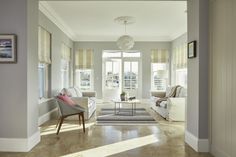 a living room filled with furniture and windows