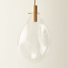 a clear glass light bulb hanging from a wooden hook on a white wall with a wood stick sticking out of it