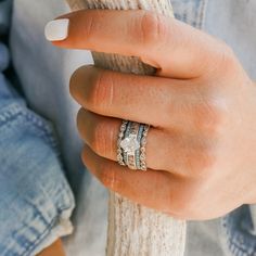 a woman's hand with two rings on top of her finger and the other ring in