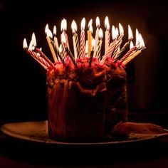 a birthday cake with many lit candles on it