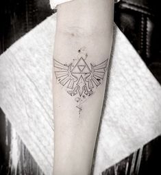 a tattoo on the arm of a person with a bird and triangle design in it