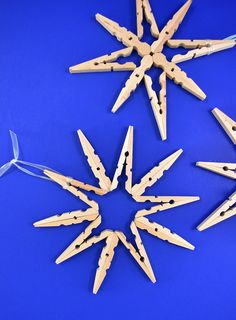 wooden pegs are arranged in the shape of a snowflake on a blue background