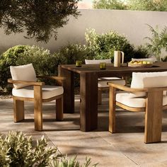 an outdoor table and chairs with white cushions