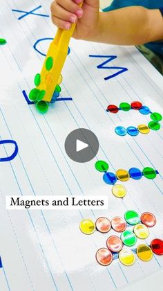 a child's hand holding a pencil and writing letters on a sheet of paper