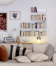 a living room filled with lots of furniture and bookshelves on top of it