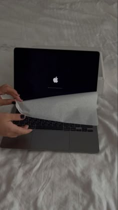 a person is typing on the keyboard of an apple laptop