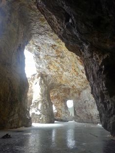 the inside of a cave with sunlight coming through