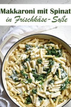 a pan filled with pasta and spinach on top of a table