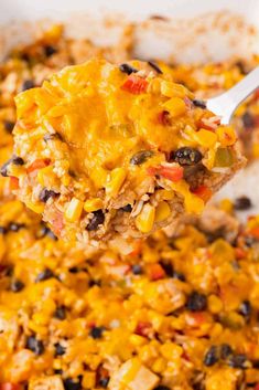 a spoonful of mexican rice and beans is being lifted from the casserole dish