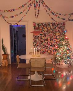 a dining room with a christmas tree in the corner and decorations on the wall above it