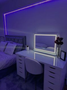 a white desk with a mirror and some drawers in a room next to a bed