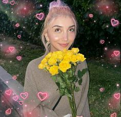 a woman holding a bouquet of yellow roses in front of her face with pink hearts