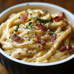 pasta with bacon and parsley in a white bowl on a wooden table, ready to be eaten