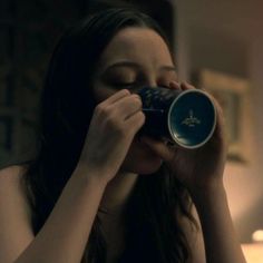 a woman drinking from a can with her eyes closed