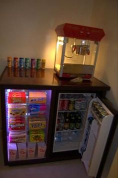 a small refrigerator with drinks and sodas in it's display case next to a mini fridge