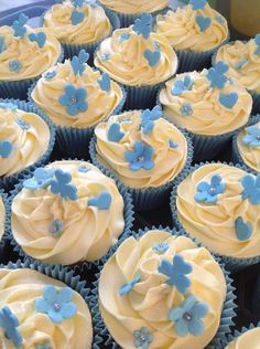 many cupcakes with blue and white frosting on them