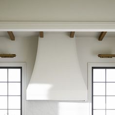 a large white stove top oven sitting inside of a kitchen next to two black windows