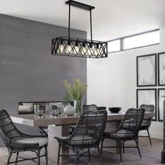 a dining room table with chairs and pictures on the wall behind it in front of a fireplace