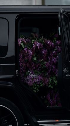 a black car with purple flowers in the back door