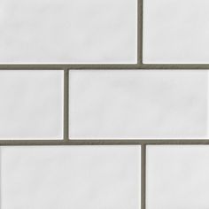 a white brick wall with grey grouting