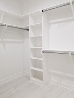 an empty closet with white walls and shelves