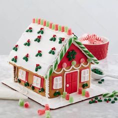 a gingerbread house is decorated with icing and sprinkles for the holiday season