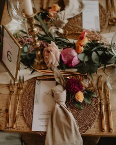 the table is set with flowers and place settings