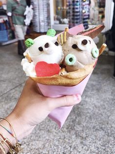 a person holding up a cupcake with three different toppings