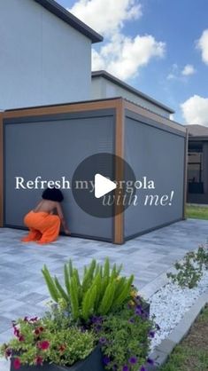 a person sitting on the ground in front of a building with an open garage door