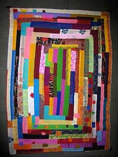 a multicolored quilt hanging on the wall