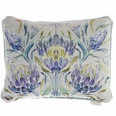 a blue and white pillow with purple flowers on it