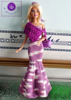 a barbie doll wearing a crocheted dress and holding a purse in her hand