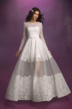 a woman in a white dress with long sleeves and sheer lace on the skirt is posing for