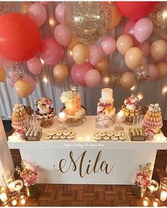 a table topped with lots of desserts and balloons