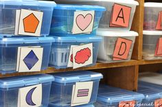 plastic bins filled with different shapes and numbers on the shelves in a classroom setting