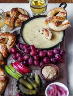 an assortment of food including bread, grapes and pretzels