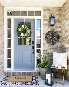 a blue front door with flowers on it and a welcome mat next to the door