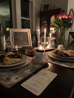 a dining room table set with plates and candles