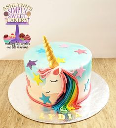 a birthday cake decorated with an unicorn's head and stars