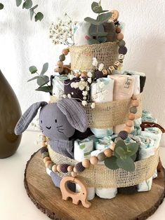 a baby shower cake made out of burlaps and fabric with an elephant figurine on top