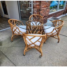 a glass table with four chairs sitting on top of it