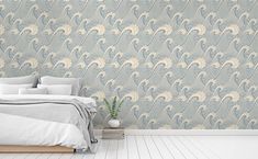 a bedroom scene with focus on the bed and wallpaper that looks like an ocean wave