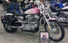 several motorcycles are on display in a showroom, some with pink and blue paint